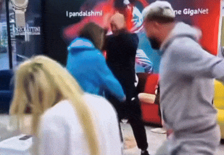 a man and a woman are fighting in front of a sign that says giganet