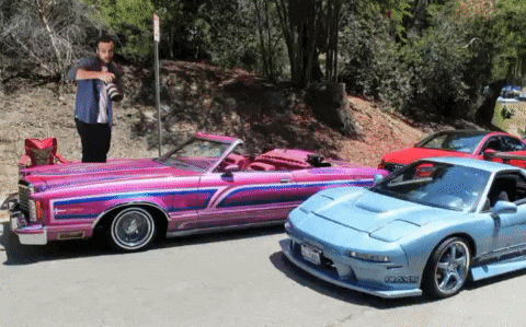 a pink car and a blue car are parked next to each other
