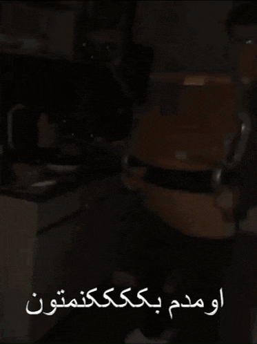 a person sitting in a chair with arabic writing on the bottom