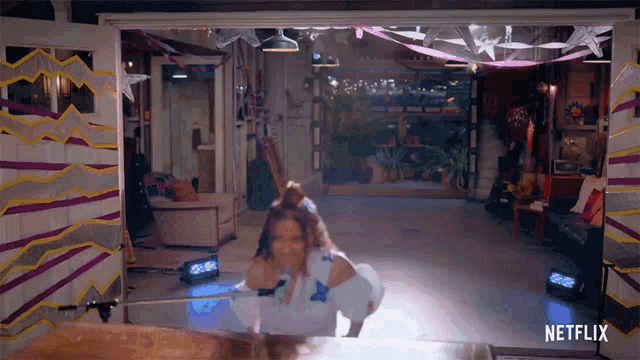 a woman is dancing in a room with netflix written on the bottom