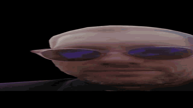 a close up of a man wearing pink sunglasses with purple lenses