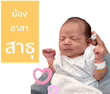 a baby is being held in a person 's arms with a pink heart .
