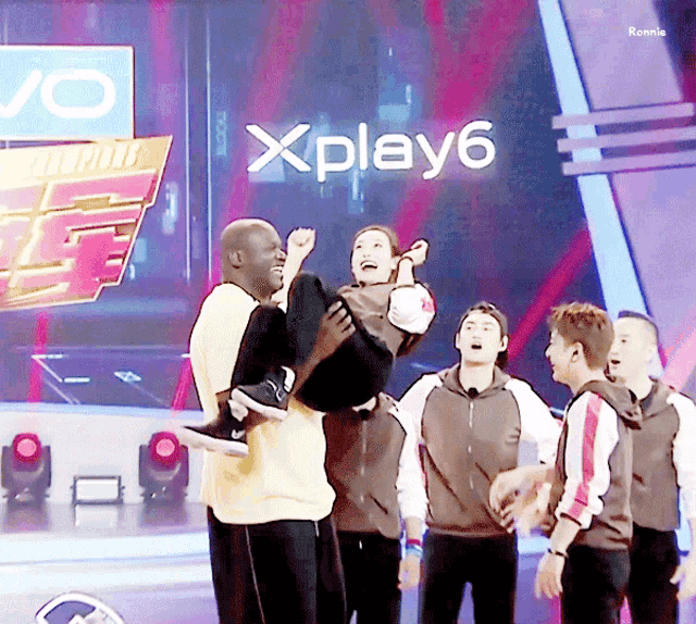 a group of people standing in front of a sign that says xplay
