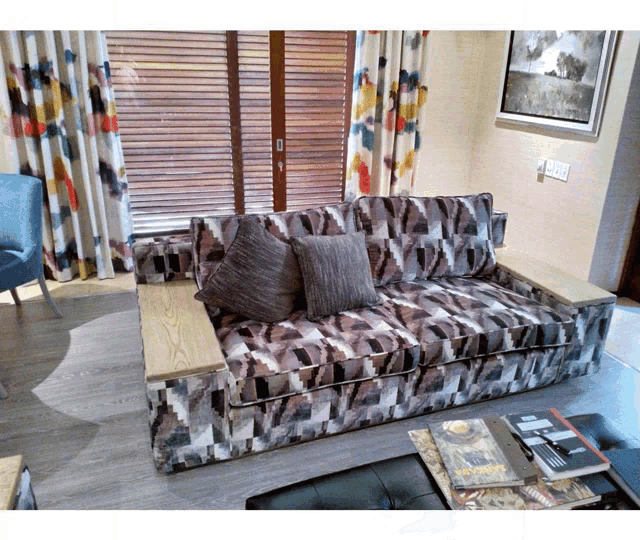 a couch with a geometric pattern sits in a living room next to a table