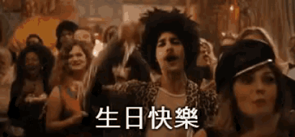 a man in a wig is dancing in front of a crowd at a birthday party .