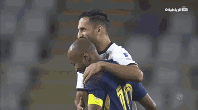two soccer players standing next to each other on a field