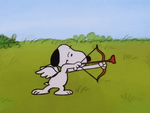 snoopy holding a bow and arrow in a field