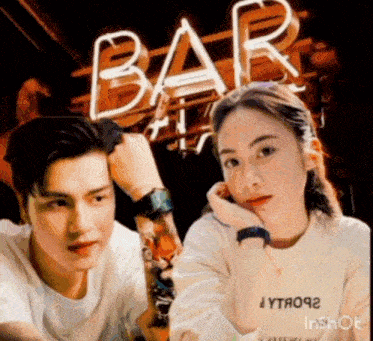 a man and a woman are sitting in front of a neon sign that says bar
