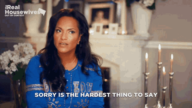 a woman says sorry is the hardest thing to say in front of a fireplace and candles