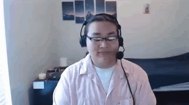 a man wearing headphones and glasses is sitting in a room .