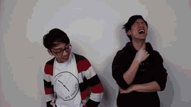 a man wearing a t-shirt that says 40 hours laughs next to another man