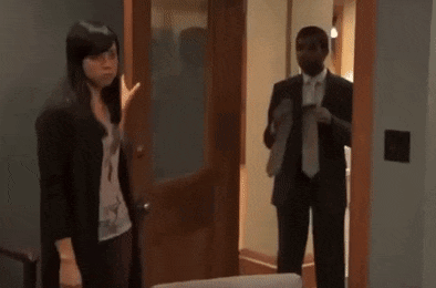 a man in a suit and tie is standing next to a woman in a suit .