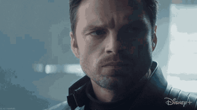 a close up of a man 's face with a disney + logo in the corner