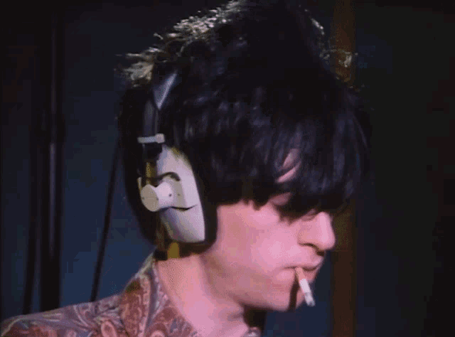 a man wearing headphones and a cigarette in his mouth
