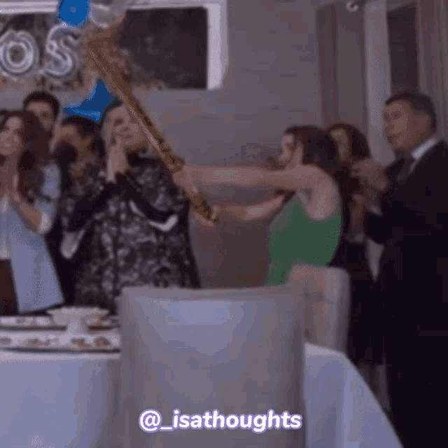 a group of people standing around a table with a purple sticker that says ' @_isathoughts ' on it