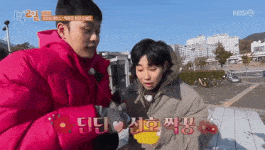 a man in a pink jacket is standing next to a woman in a pink jacket .