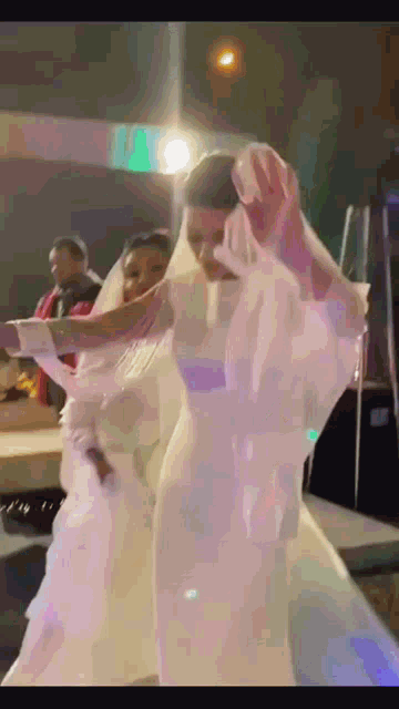 a woman in a wedding dress is dancing with a man in a red shirt