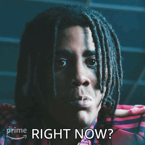 a man with dreadlocks is looking at the camera with the words right now behind him