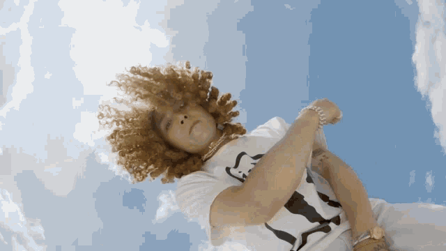 a person with curly hair wearing a t-shirt with a bear on it