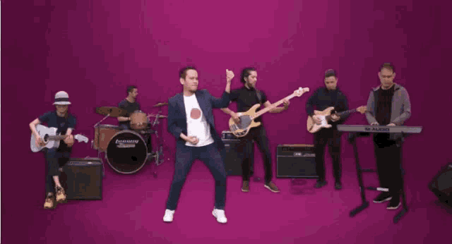 a man in a white shirt is dancing in front of a m audio keyboard