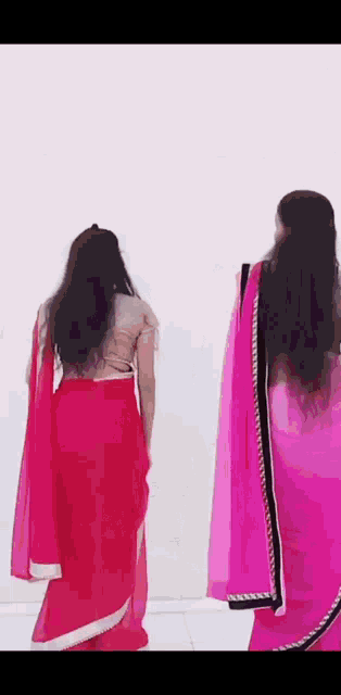 two women in pink dresses are standing next to each other