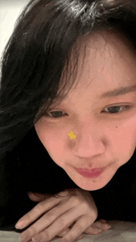 a close up of a woman 's face with a star on her nose