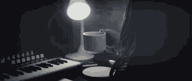 a person is playing a keyboard with a cup of coffee and a piece of paper that says ' snoopy ' on it