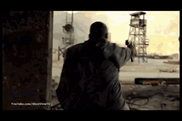 a man holding a gun in front of a youtube.com/xboxview tv advertisement