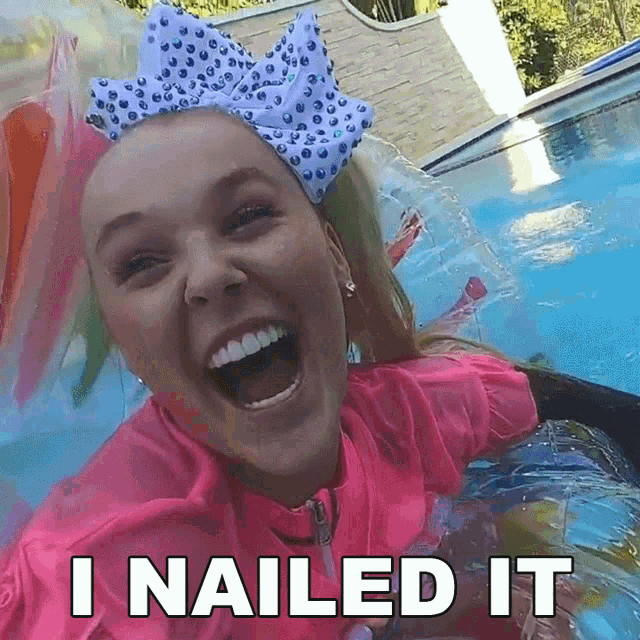 a girl with a bow on her head is laughing in a pool with the words `` i nailed it '' below her .