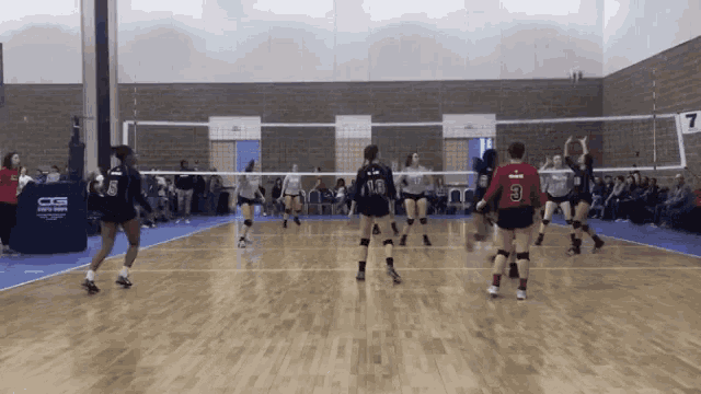 a volleyball game is being played in a gym with the number 7 on the net