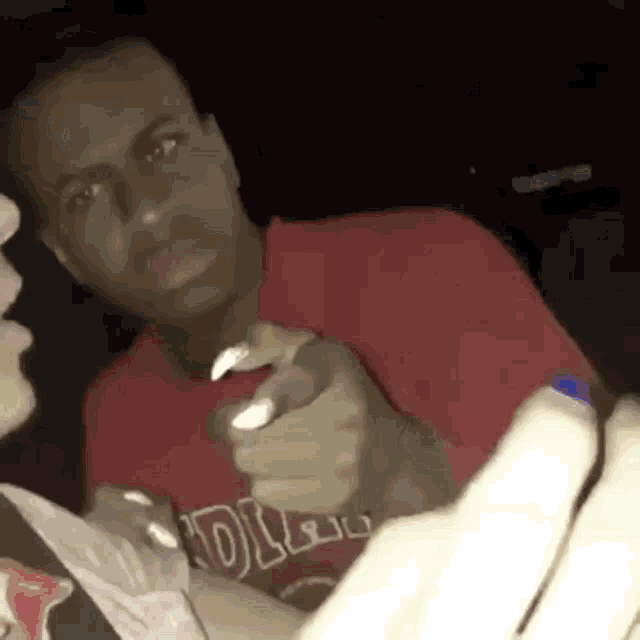 a man in a red shirt is holding a bottle of water and a bag of food .