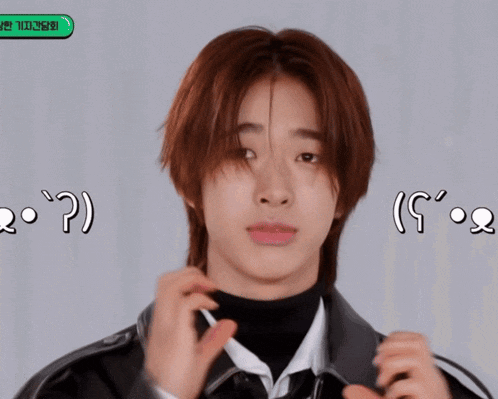 a young man with long red hair is making a funny face with a green button that says ' ? ' on it