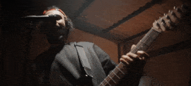 a man is singing into a microphone with headphones on