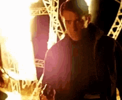 a man in a purple jacket is holding a gun in his hand .