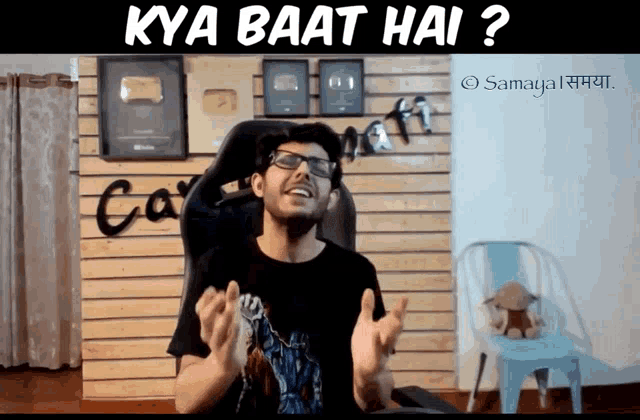 a man sitting in a chair with the words kya baat hai on the top