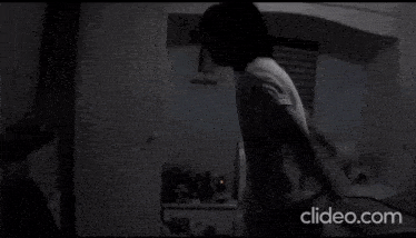 a person is standing in a dark room with the words clideo.com on the bottom