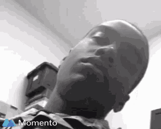 a man is sleeping in a room with his eyes closed .