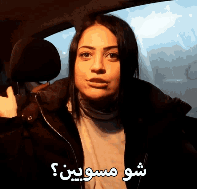 a woman in a car with arabic writing on the side