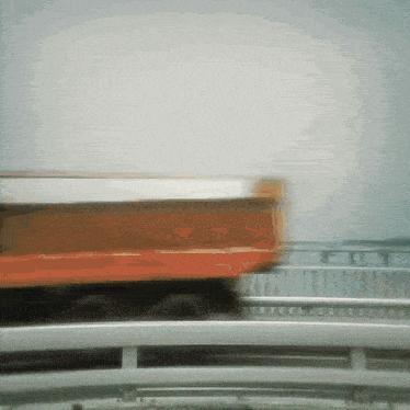 a blurred image of a dump truck on a bridge