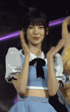 a girl in a blue dress with a black bow on her neck