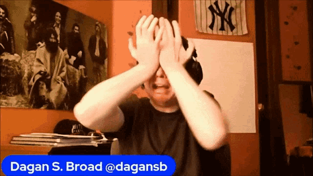 a person covering their face with their hands with the name dagan s. broad written below them