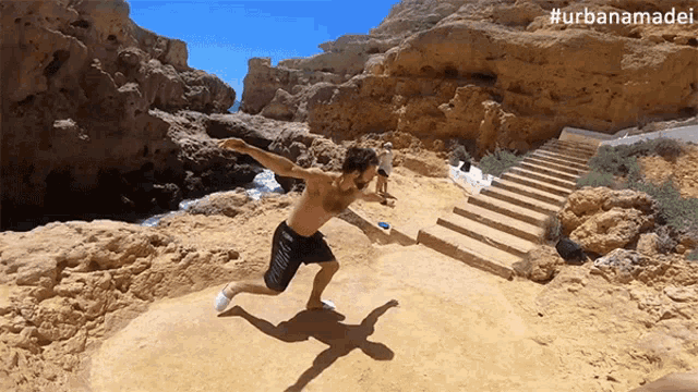 a shirtless man throws a frisbee on a sandy beach with the hashtag #urbanamadei on the bottom