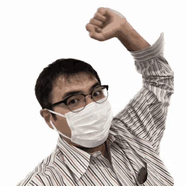 a man wearing a mask and glasses holds his fist up