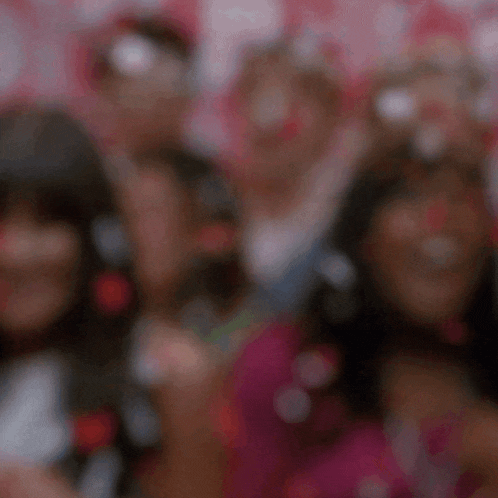 a blurry photo of a group of people with hearts on their faces .