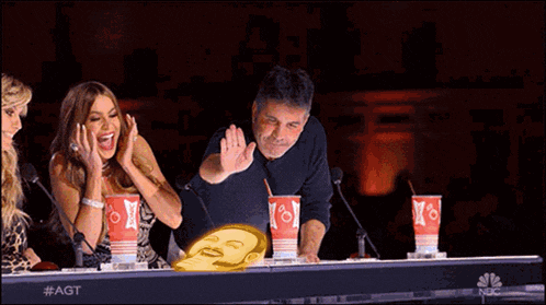 a group of people sitting at a table with cups that say nbc on them