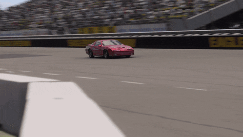 a red car is driving on a race track with a sign that says bfgoodrich on it