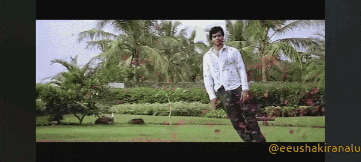 a man in a white shirt and black pants stands in a park