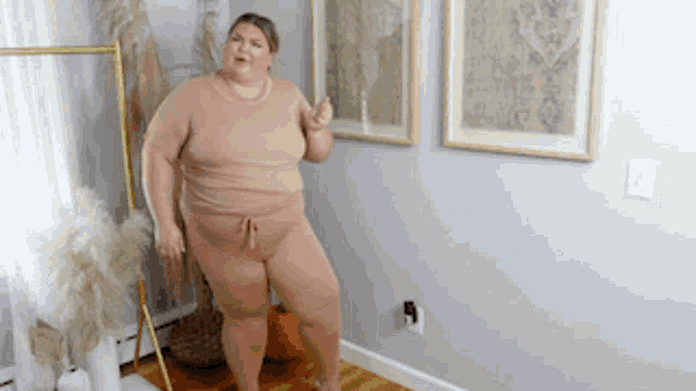 a woman is standing in a room with a pumpkin in the background .