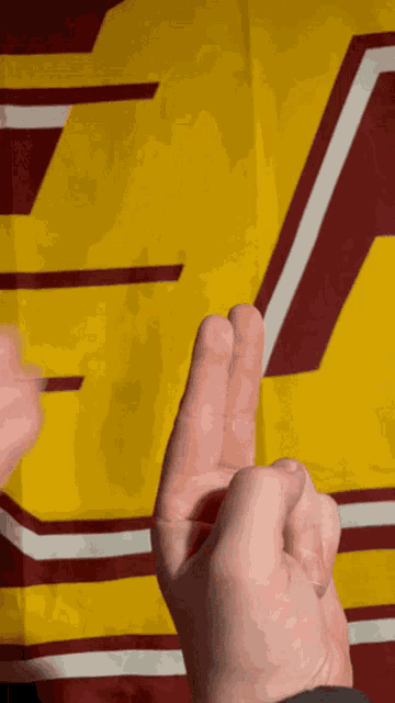 a close up of a person 's hand against a yellow background