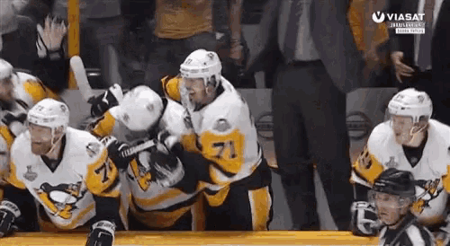 a hockey player with the number 71 on his jersey hugs another player